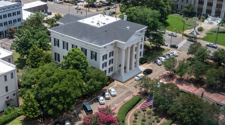 an aerial view of the courthouse with cars parked in front